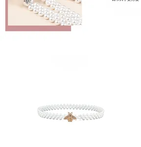 Détail d'une élégante ceinture en perles avec une boucle abeille dorée sertie de strass