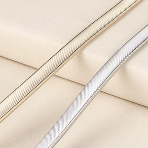 Makroaufnahme elastischer Metall-Taillengürtel in Gold und Silber mit Schlangenkette