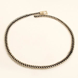 Close-up of golden metal chain and black leather woven waist belt with a gold rectangular buckle