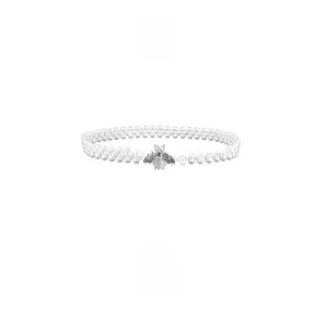 Détail de la boucle abeille argentée et des perles sur une ceinture élastique élégante