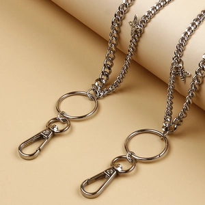 Macro detail of silver pants chain with bee charms and large lobster clasps on denim accessory