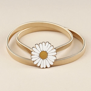 Detaillierte Makroansicht einer goldenen elastischen Metall-Taille mit Gänseblümchen-Schnalle