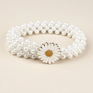 Détail d'une chaîne de taille en perles à plusieurs rangs avec marguerite blanche