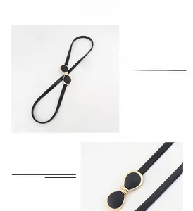 Détails d'une ceinture fine noire avec une boucle dorée en forme d'infini pour femme