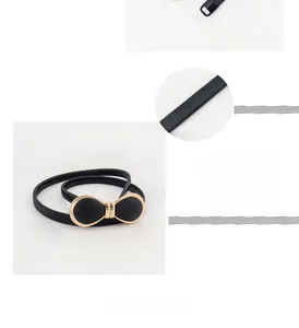 Vue détaillée de la ceinture élastique noire avec boucle noeud doré et texture fine