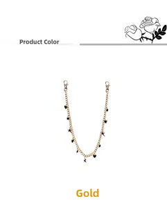 Detail of gold pants chain with black heart and star charms and lobster clasps