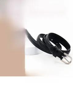 Détail d'une fine ceinture en cuir noir avec une boucle à ardillon en métal argenté