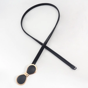 Détail d'une ceinture élastique fine avec boucle nœud papillon doré pour manteaux