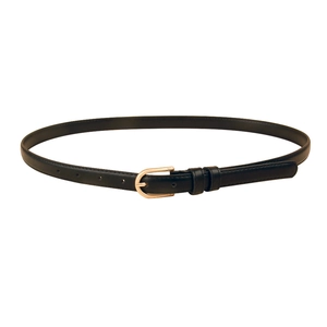 Détail d'une fine ceinture en cuir noir avec une boucle fer à cheval dorée polie