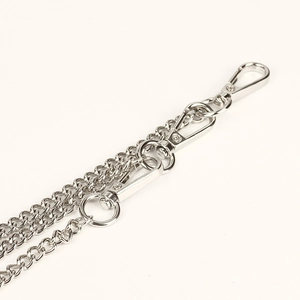 Detailed close-up of three swivel lobster clasps on a stylish silver triple layer pants chain