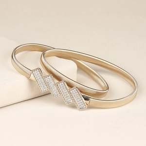 Detail of light gold elastic metal waist belt with geometric rhinestone buckle on stone