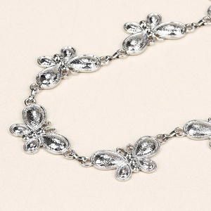 Close-up detail of silver butterfly chain links with textured metallic surface finish
