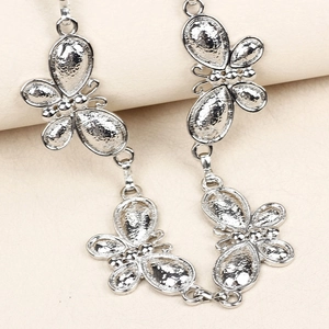 Detailed close-up of metallic butterfly chain link with matte and polished finishes