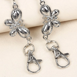 Silver metal butterfly pant chain accessory with textured wings and lobster clasp detail