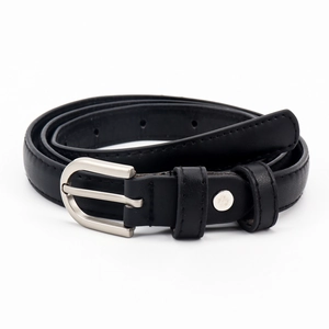 Détail d'une ceinture en cuir noir avec boucle argentée mate et coutures renforcées