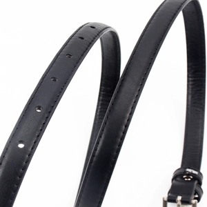 Vue détaillée d'une ceinture fine en cuir noir avec boucle argentée et couture