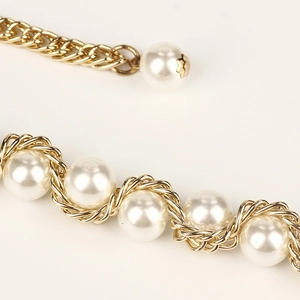 Elegante goldene Körperkette mit gewebten Perlen und gedrehten Metallgliedern Detail
