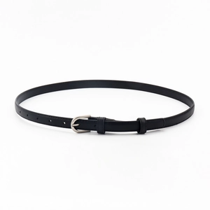 Détail d'une ceinture fine en cuir noir avec boucle en D argentée et texture de grain fine