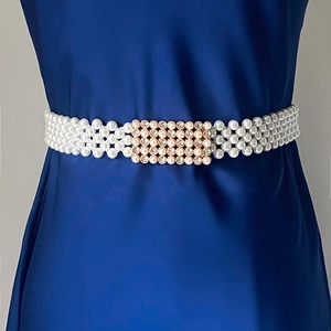 Detail van elastische parelriem met vier rijen en een gouden gesp met strass-stenen