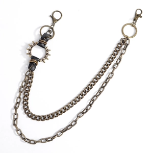 Détail d'une chaîne de taille punk avec pointes en métal bronze et lien en cuir