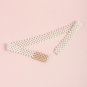 Detail van meerrijige parelmoer tailleketting met goudkleurige gesp met kristallen