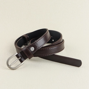 Vue détaillée d'une ceinture en cuir marron foncé avec boucle argentée et couture fine