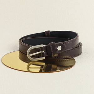 Détail de ceinture en cuir marron foncé avec boucle fer à cheval argentée sur miroir