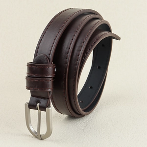 Détail d'une ceinture en cuir marron foncé avec boucle mate argentée et coutures renforcées