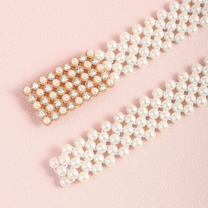Elegante meerlaagse parel-tailleketting met een fonkelende geometrische gouden gesp