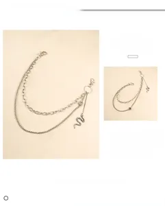 Detail view of double-layered silver trousers chain featuring snake pendant and lobster clasp