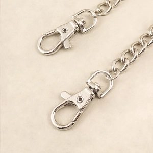 Detailaufnahme der silbernen Metallkette mit Karabinerverschluss und Herzanhänger