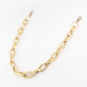 Detail of chunky gold punk style pants chain with metal lobster clasps for trousers