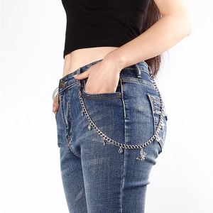 Detail der silbernen Hosenkette mit Herzanhängern und Schmetterling an einer Jeans
