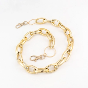 Detail of chunky gold punk chain with lobster clasps and hollow circular rings for trousers