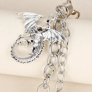 Macro shot of silver winged dragon charm with metallic chain and intricate texture