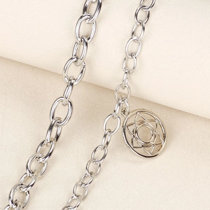 Macro view of silver hexagram dragon pendant and classic oval link chain details