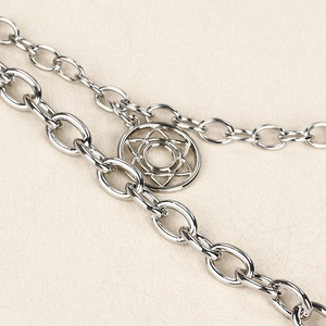 Close-up of double-layered silver chain with a geometric mandala-style circular pendant