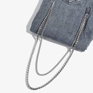 Dual-layer silver metal pants chain with heavy square links on blue denim backdrop