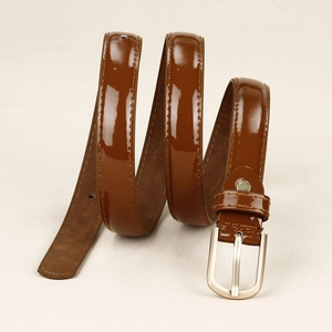 Détail d'une ceinture en cuir marron brillant avec boucle métallique en forme de D