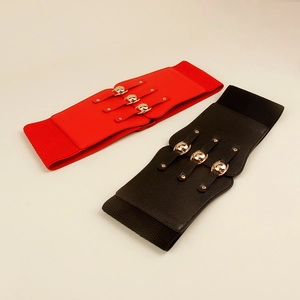 Detail of wide elastic waist belts in red and black with golden metal studs decoration