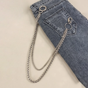 Detail of silver double-layered metal trousers chain with lobster clasps and ring on grey jeans