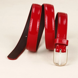 Détail d'une ceinture en cuir verni rouge avec boucle en métal argenté et couture