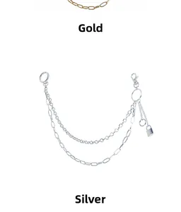 Close-up of gold and silver double-layered metal trouser chains with lock pendants