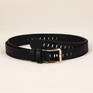 Détail d'une ceinture noire en similicuir avec boucle dorée et trous réglables
