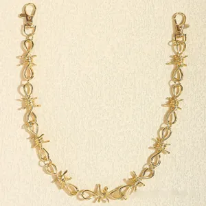 Detail of a golden punk style waist chain with barbed wire links and lobster clasps