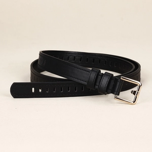 Détail de la ceinture noire en cuir grainé avec boucle carrée en métal doré poli