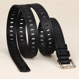 Détail de la ceinture en cuir noir avec boucle dorée et motifs creux rectangulaires