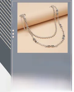 Detail of double-layer silver trouser chain with skull charms and safety pin clip