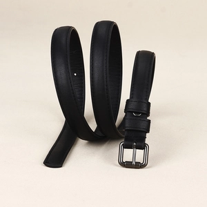 Détail de la ceinture en cuir noir avec boucle en métal gris foncé et coutures fines