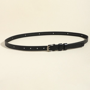 Détails d'une ceinture fine en cuir noir avec perforations en étoile et boucle argentée